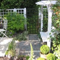 Pergola avec un banc devant l'entrée du jardin