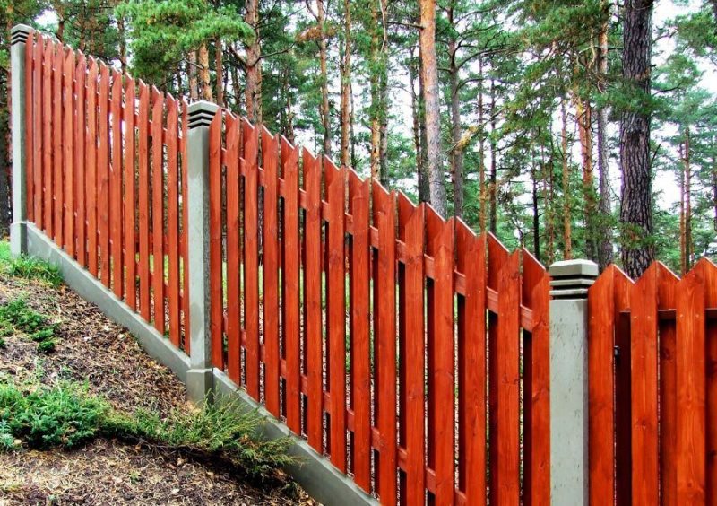 Clôture en bois sur la pente d'un chalet d'été