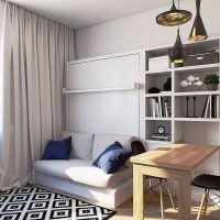 Maža sofa studijos tipo apartamentų poilsio zonoje