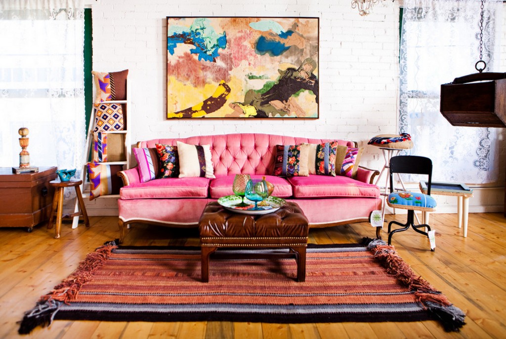 Rožinė sofa boho stiliaus kotedžo kambaryje